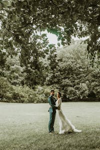 Elegant wedding couple in a lush park setting, capturing love and elegance.